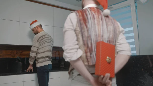 Ο Χάντσομ γκέι άντρας κάνει έκπληξη στο σύντροφό του με χριστουγεννιάτικο δώρο. Οικογενειακή έννοια — Φωτογραφία Αρχείου