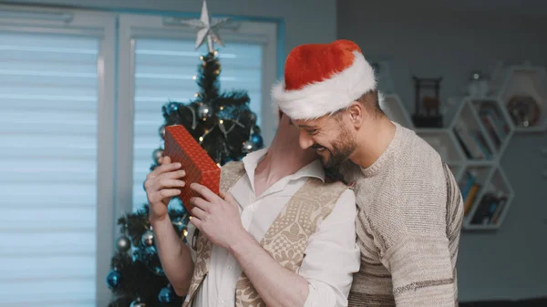 Χριστούγεννα στην οικογένεια των γκέι. Ευτυχισμένοι φίλοι γιορτάζουν τα Χριστούγεννα μαζί με αγκαλιές και δώρα — Φωτογραφία Αρχείου