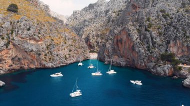 Serra De Tramuntana, Sa Calobra, Torrent De Pareis plajı, Akdeniz 'in havadan, kristal berrak suları kıyıya doğru giden yelkenli tekneler ve yatlar.