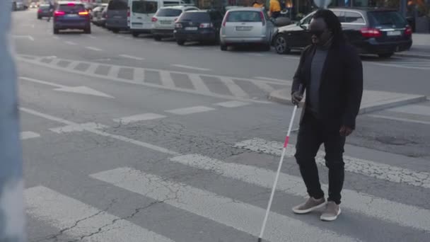 Ślepy afrykański czarny mężczyzna przechodzący przez przejście z kijem do chodzenia — Wideo stockowe