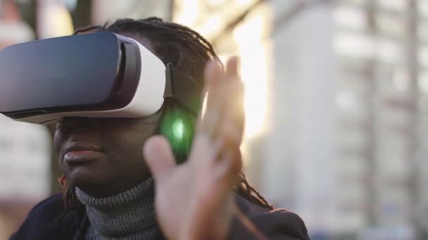 Homem negro afro-americano vestindo fone de ouvido VR no parque. Primeiro toque com realidade virtual — Vídeo de Stock