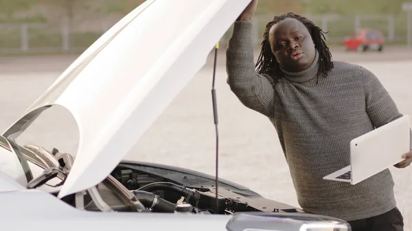 Mobil araba yardımı. Afrikalı Amerikalı siyahi adam laptopuyla bozuk arabayı kontrol ediyor. — Stok fotoğraf