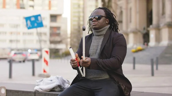 Blinde Afro-Amerikaanse zwarte man met zonnebril opent zijn wandelstok en loopt weg van de bank — Stockfoto