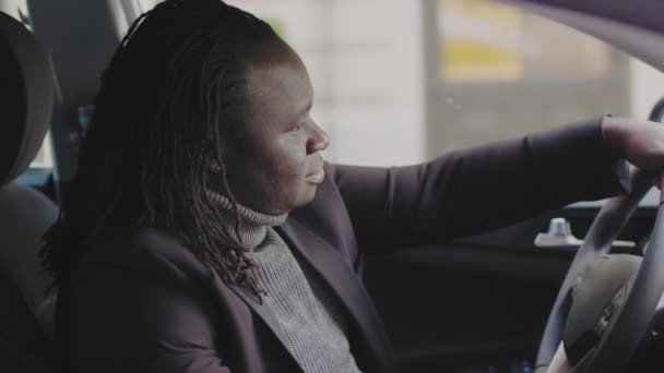Młody afrykański czarny biznesmen siedzi na foteliku kierowcy i pokazuje kciuk w górę — Wideo stockowe