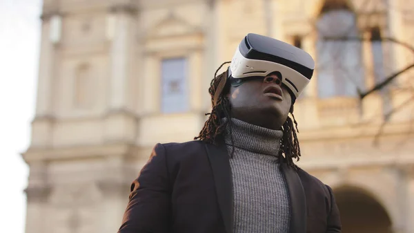 Virtual reality. Black man with VR headset on the city street