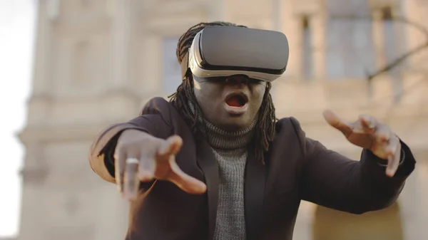 Изучение виртуальной реальности и киберпространства. Африканский американец с VR гарнитурой на улице — стоковое фото