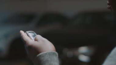 Yaklaş, siyah adam arabanın anahtarlarını tutuyor ve arabanın kilidini açıyor.