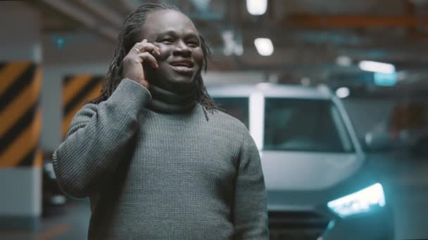 快乐的黑人男人在地下停车场边打电话边笑 — 图库视频影像