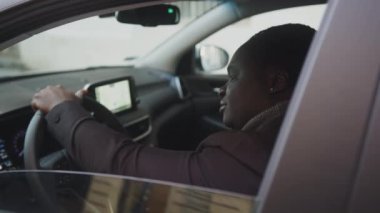 Mutlu Afrikalı Amerikalı siyah adam yeni arabasından gülümsüyor.