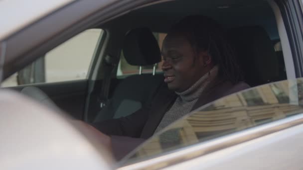 Podekscytowany afrykański czarny mężczyzna siedzi w swoim nowym samochodzie. — Wideo stockowe
