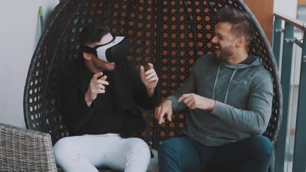 Sanal dünya. Neşeli eşcinsel çift VR gözlük takıyor ve balkonda dinleniyorlar. — Stok video