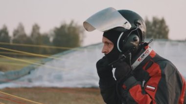 Paraglider kalkıştan önce kaskını ayarlıyor. Kapat.