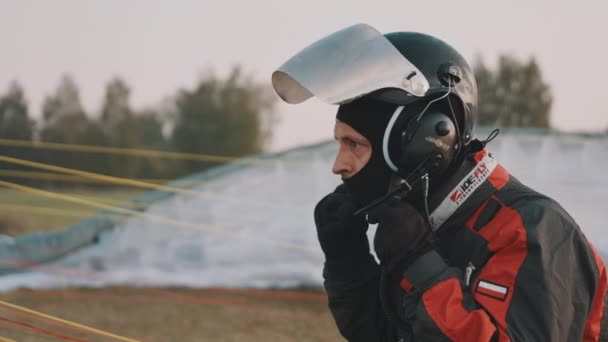 Parapente ajustando seu capacete de segurança antes de decolar. Fechar — Vídeo de Stock