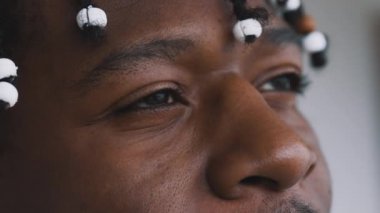 Yakın, barışçıl bakışlar Afro-Amerikan siyah adamın gözlerinde gökyüzüne bakıyor.