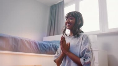 Güzel, Afro-Amerikan siyahi kadın yatak odasında meditasyon yapıyor. Yüzünde gülümsemeyle ilk meditasyon denemesi
