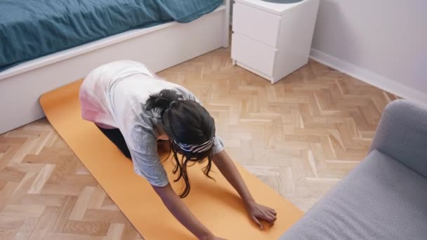 Jeune femme afro-américaine méditant et s'étirant sur le tapis de yoga dans sa chambre — Video