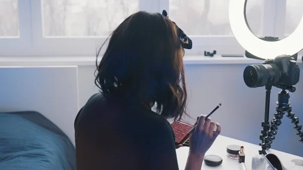 Jeune femme aux cheveux noirs appliquant maquillage devant la caméra — Photo