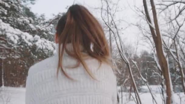 Close up, Jovem pulando na estrada coberta de neve, se divertindo no parque no inverno — Vídeo de Stock
