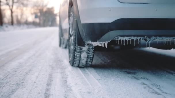 凍結車の道路の雪の後ろに煙を残して覆われて運転。車輪を閉めろ — ストック動画