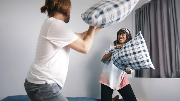 Casal jovem feliz tendo almofadas lutar no quarto. Conceito de amor e afeto — Fotografia de Stock