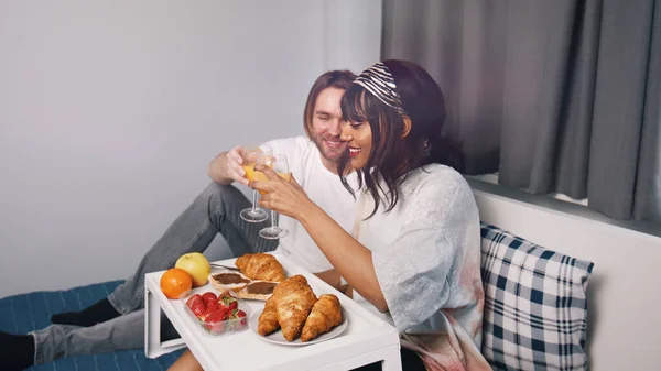 Happy newlywed couple enjoying breakfast in bed. — Stockfoto