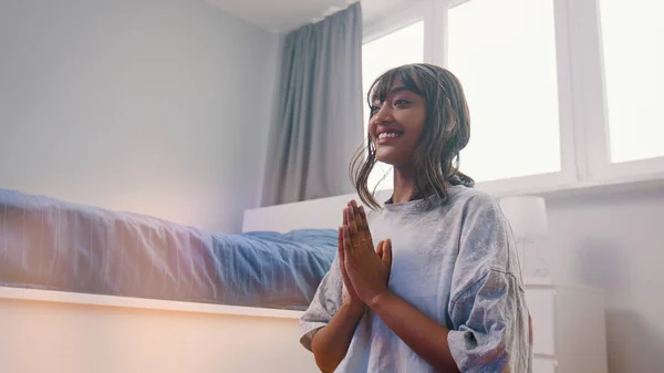 Vacker ung afrikansk svart kvinna mediterar i sitt sovrum. första meditationsförsök med leende på läpparna — Stockfoto