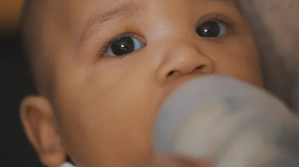 Close up, bebê de pele escura bebendo seu leite do bebê da garrafa — Fotografia de Stock