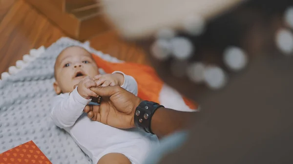 Sevimli bebek, babasının elini tutuyor. Mulatto bebek babasının eliyle oynuyor. Kapat. — Stok fotoğraf
