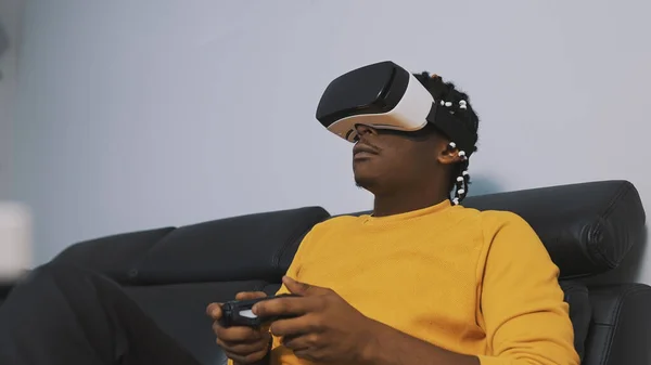 Wirtualna rzeczywistość. Afrykański czarny mężczyzna gra w gry za pomocą zestawu słuchawkowego VR i joystick — Zdjęcie stockowe