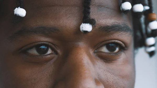 De cerca, ojos de hombre negro afroamericano confiado con trenzado escuchar mirando a la cámara —  Fotos de Stock