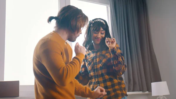 Happy young couple dancing in front of the window — Stock Photo, Image