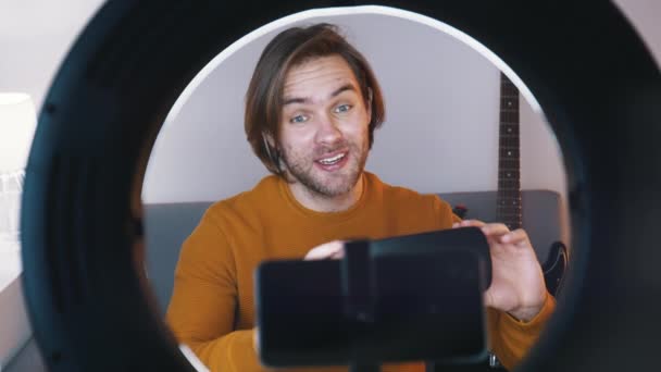 Ung kaukasisk man influencer inspelning video på sin smartphone samtidigt som vr glasögon — Stockvideo