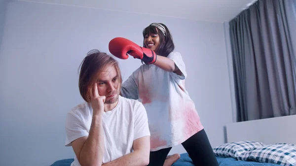 Jonge vrouw met bokshandschoenen proberen op te vrolijken haar boos vriendje — Stockfoto