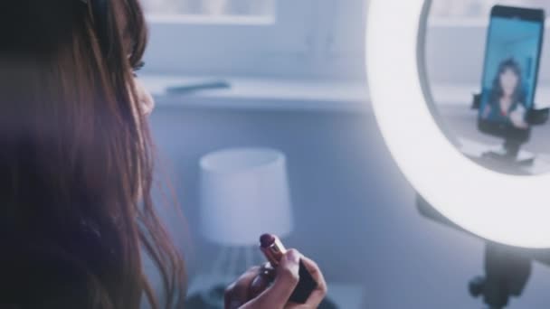 Wanita muda mengaplikasikan lipstik dan merekam membuat tutorial — Stok Video