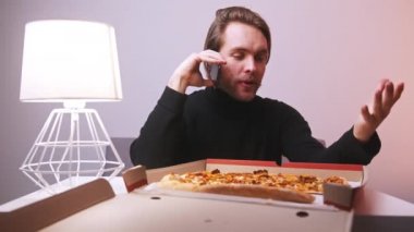 Telefondaki adam pizza siparişinden şikayetçi. Dilimi kutuya geri atıyorum.