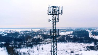 Karla kaplı 5G anteninin etrafında dönen insansız hava aracı. 