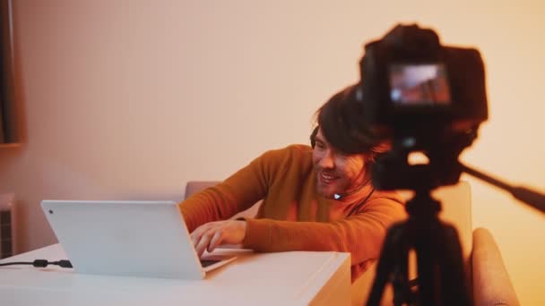 Молодий чоловік грає в гру на ноутбуці і записує на камеру dslr — стокове відео