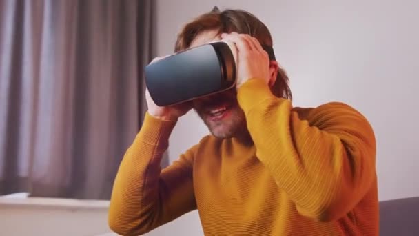 Young caucasian man overreacting while using VR headset — Stock Video