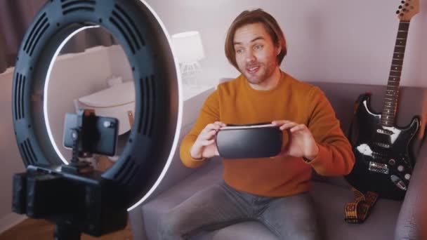 Joven influencer presentando nueva tecnología. Auriculares VR — Vídeo de stock