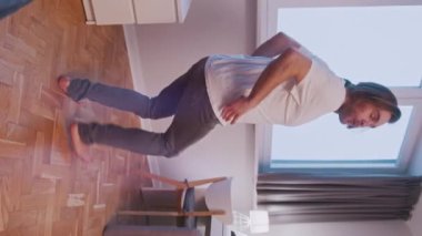 Yeni dairesinde dans eden mutlu beyaz adam.