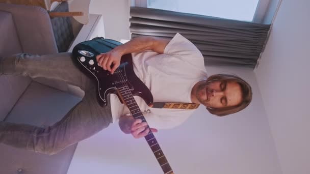 Vertical. Jovem caucasiano homem tocando guitarra — Vídeo de Stock