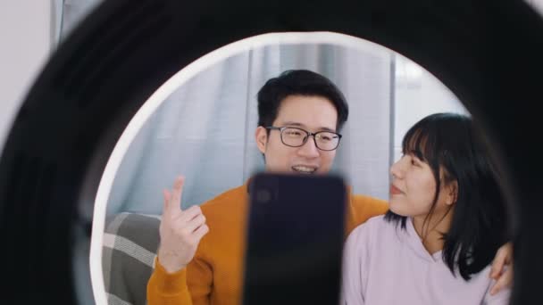Young asian couple influencers streaming video on social media using smartphone. — Stock Video