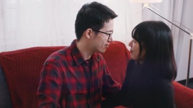 Kanepede öpüşen mutlu Asyalı çift. Romantizm ve şefkat kavramı
