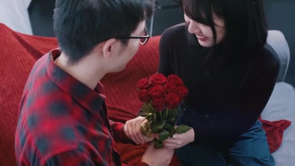 Joven hombre asiático dando rosas rojas a su novia. Feliz día de San Valentín — Vídeos de Stock