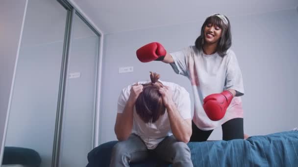 Young woman with boxing gloves trying to cheer up her upset boyfriend — Stock Video