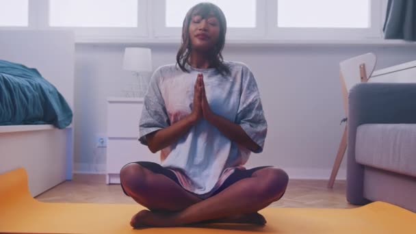 Koncepcja relaksu i dobrego samopoczucia medytacji. Młoda kobieta medytująca w swoim mieszkaniu — Wideo stockowe