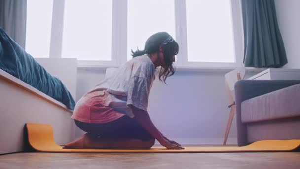 Jong Afrikaans amerikaans zwart vrouw stretching op de yoga mat in haar slaapkamer — Stockvideo