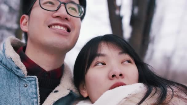 一对快乐的年轻夫妇在白雪覆盖的公园里享受冬天的散步. — 图库视频影像