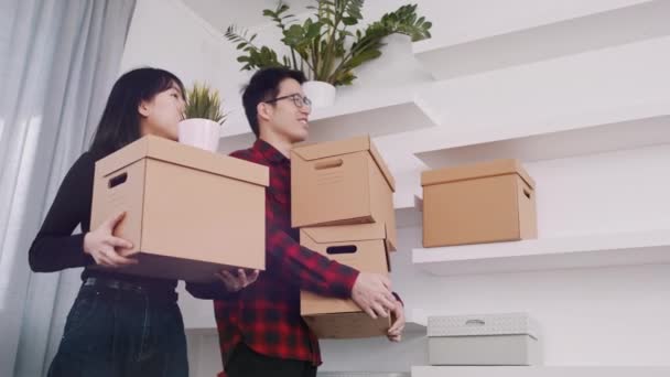 Young asian couple with cardboard boxes moving in to new appartment — Stock Video