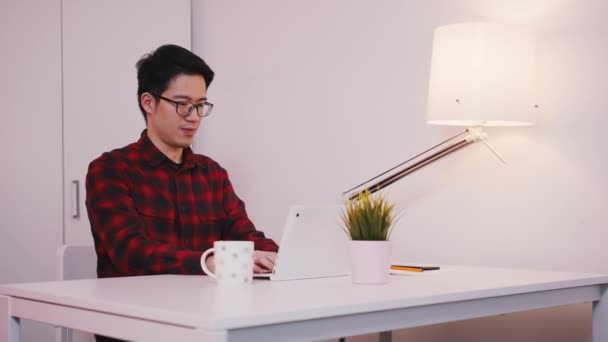 Asijský muž s brýlemi pracuje na laptopu. Dokončená práce včas — Stock video